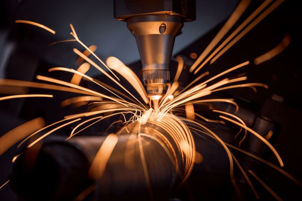 A CNC laser cutting through a metal pipe for a construction project.